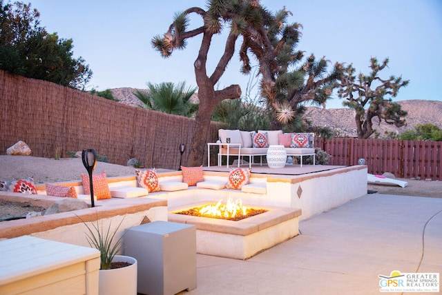 view of patio / terrace featuring a mountain view and an outdoor living space with a fire pit