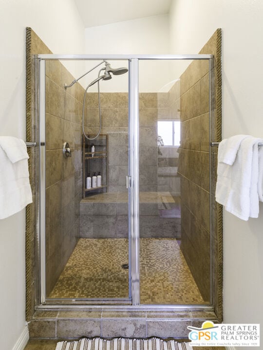 bathroom with lofted ceiling and a shower with door