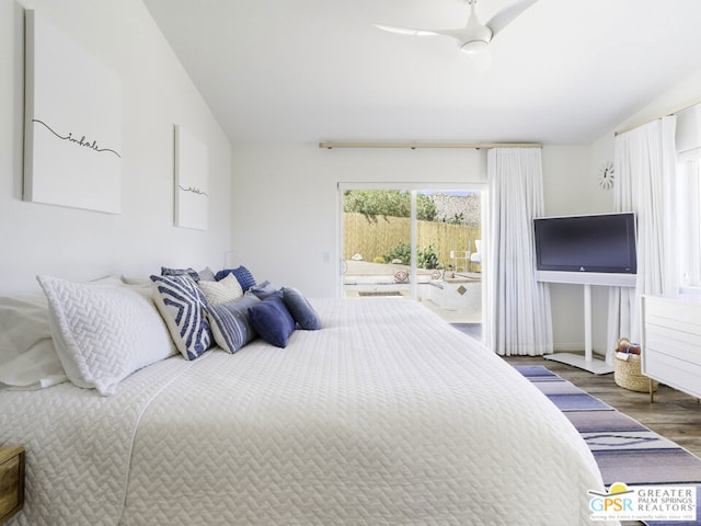 bedroom featuring lofted ceiling, dark hardwood / wood-style flooring, ceiling fan, and access to exterior