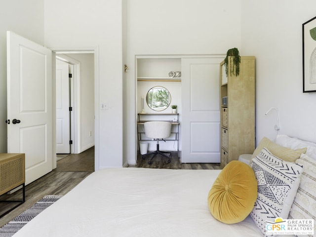 bedroom with dark hardwood / wood-style flooring and a closet