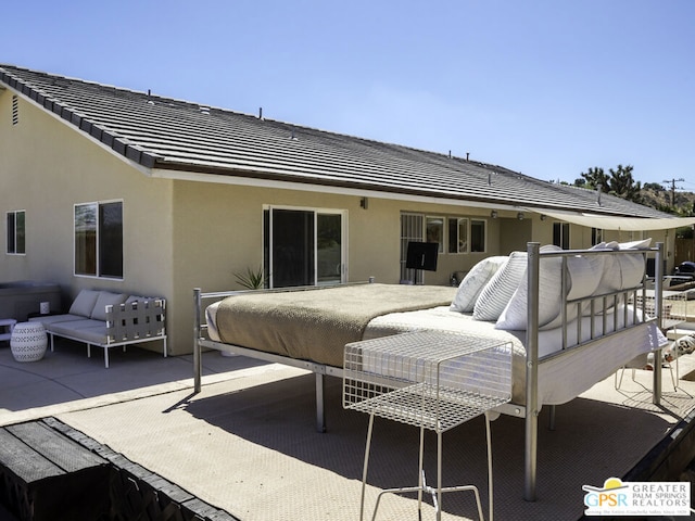 rear view of house featuring outdoor lounge area and a patio area