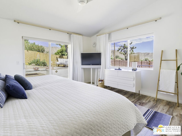 bedroom with access to outside, vaulted ceiling, and hardwood / wood-style floors