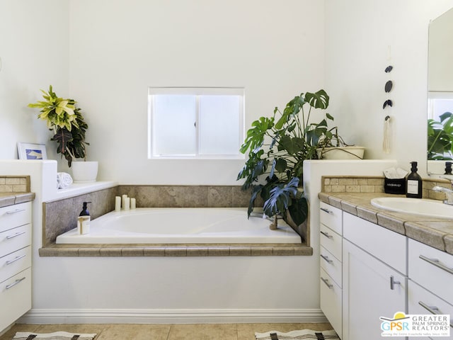 bathroom with a relaxing tiled tub, tile patterned floors, and vanity