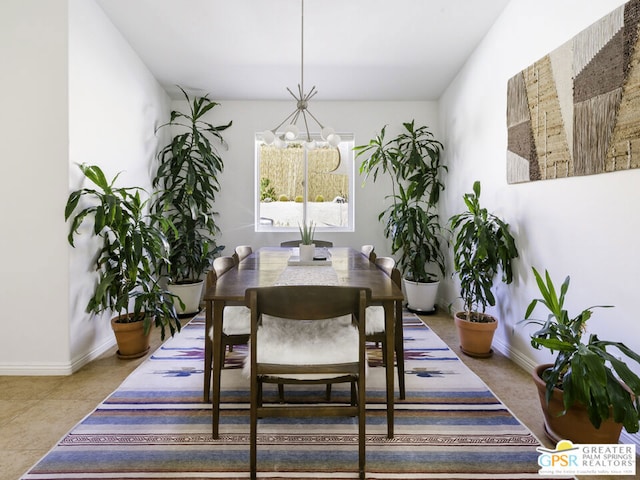 tiled dining room with a chandelier