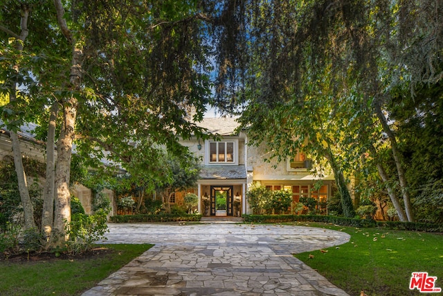 obstructed view of property featuring a front lawn