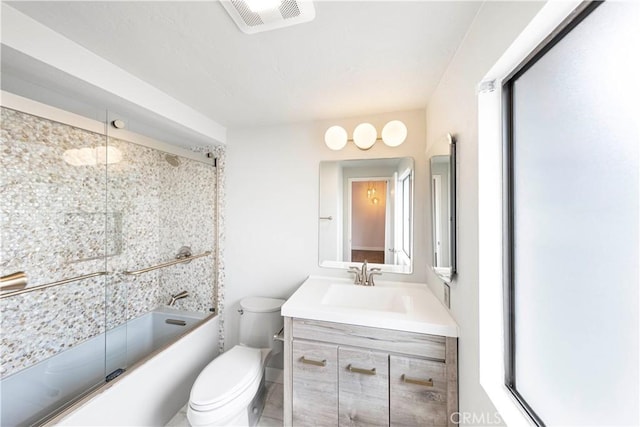 full bathroom with decorative backsplash, vanity, combined bath / shower with glass door, and toilet