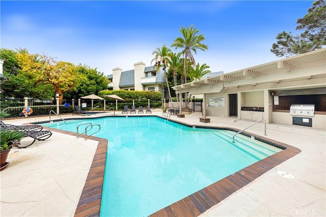 view of pool with area for grilling, a pergola, and a patio