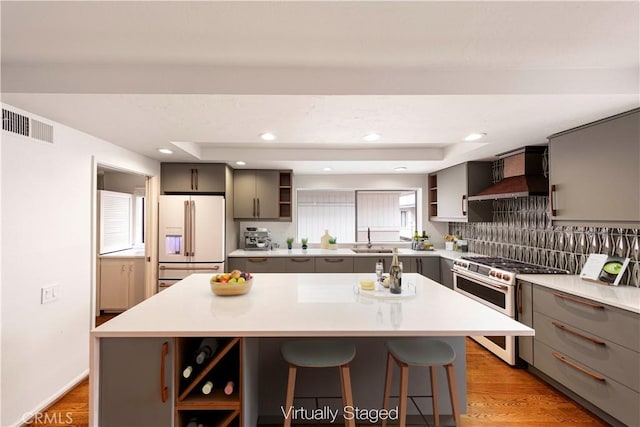 kitchen with premium range hood, range with two ovens, white fridge with ice dispenser, and a kitchen island