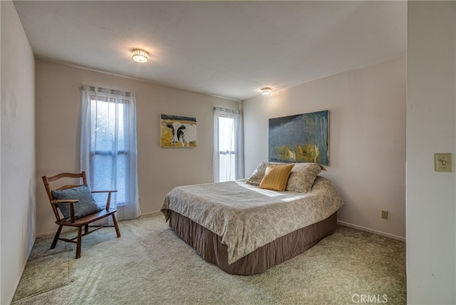 carpeted bedroom featuring multiple windows