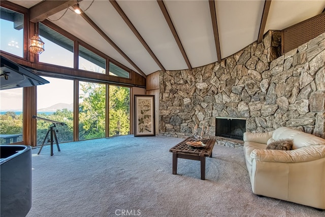 living room featuring high vaulted ceiling, a stone fireplace, beamed ceiling, a mountain view, and carpet