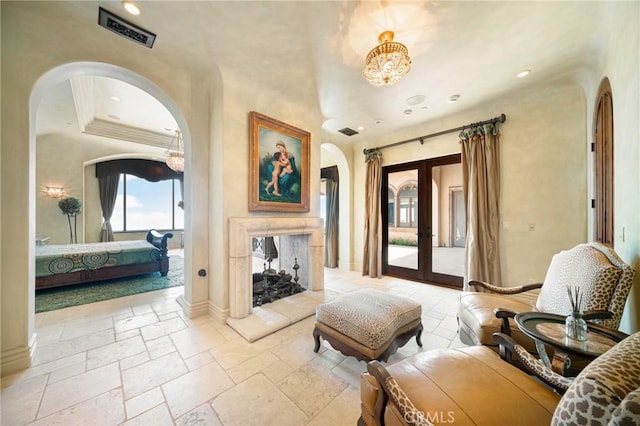 sitting room with crown molding and french doors