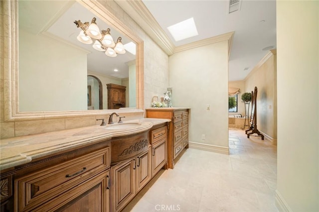 bathroom featuring tile patterned flooring, vanity, crown molding, and a skylight