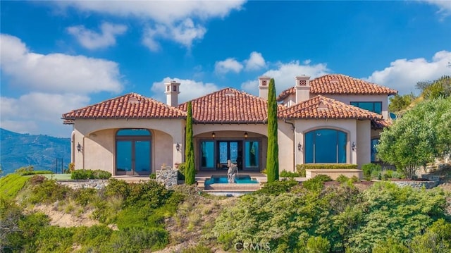 back of property featuring a mountain view and french doors