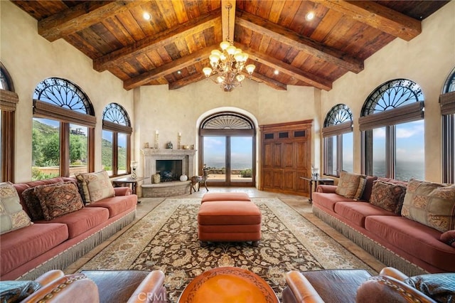 living room featuring a chandelier, a water view, high vaulted ceiling, and a healthy amount of sunlight