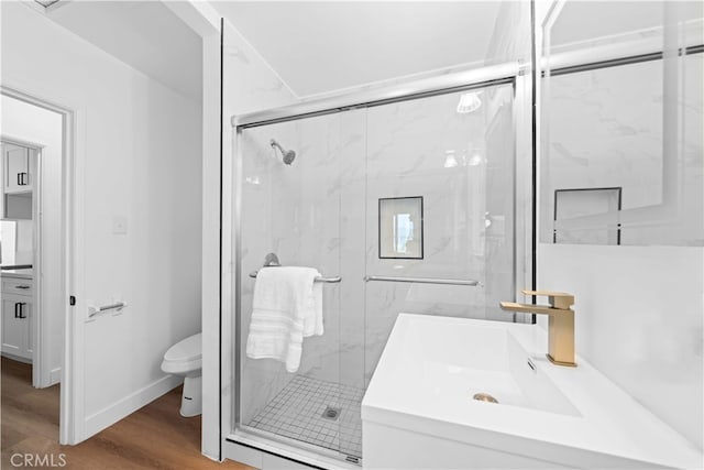 bathroom featuring walk in shower, wood-type flooring, vanity, and toilet