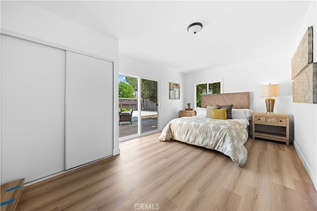 bedroom featuring access to outside, a closet, and hardwood / wood-style floors