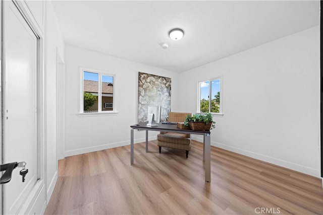 office space with light wood-type flooring and a healthy amount of sunlight