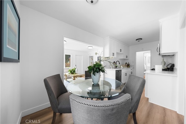 dining space with hardwood / wood-style floors and sink