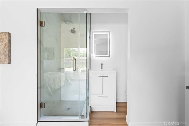 bathroom with a shower with door, toilet, vanity, and hardwood / wood-style flooring