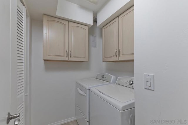 washroom featuring cabinets and washer and clothes dryer