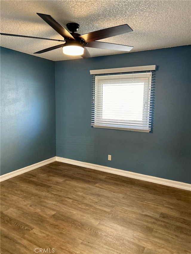 empty room with hardwood / wood-style floors and a textured ceiling