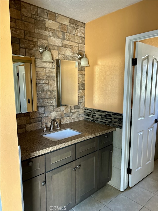 bathroom with tile patterned floors, vanity, backsplash, and a textured ceiling