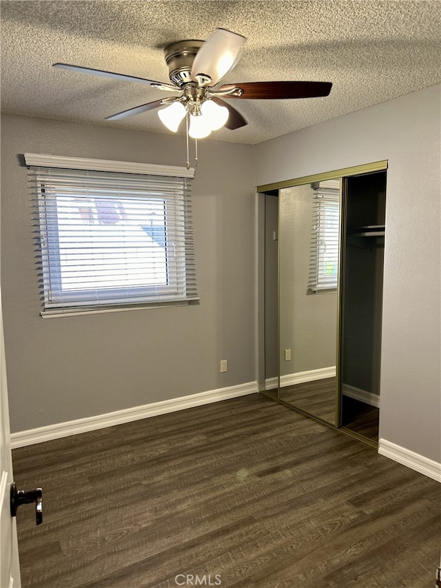 unfurnished bedroom featuring a textured ceiling, ceiling fan, a closet, and dark hardwood / wood-style floors