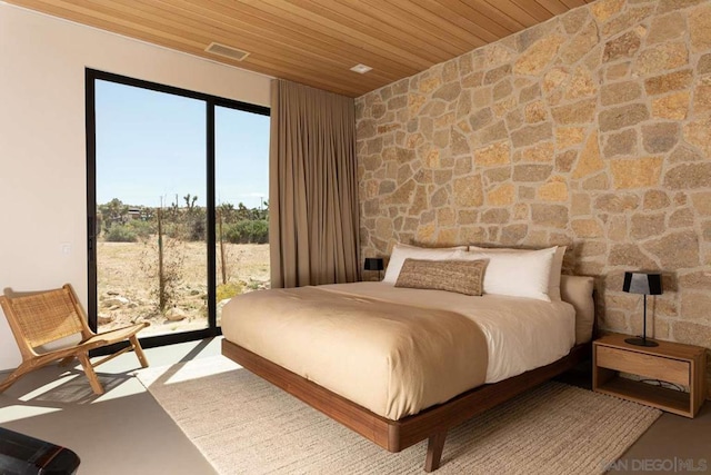 bedroom featuring multiple windows, wood ceiling, and access to exterior