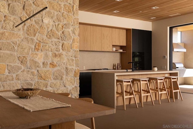 kitchen with concrete flooring, wood ceiling, and sink