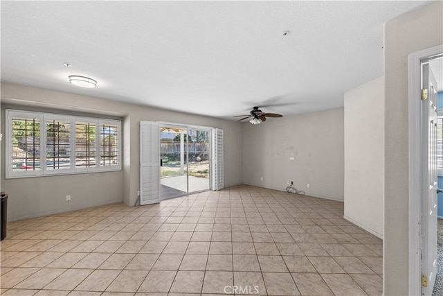 tiled spare room with ceiling fan and a textured ceiling