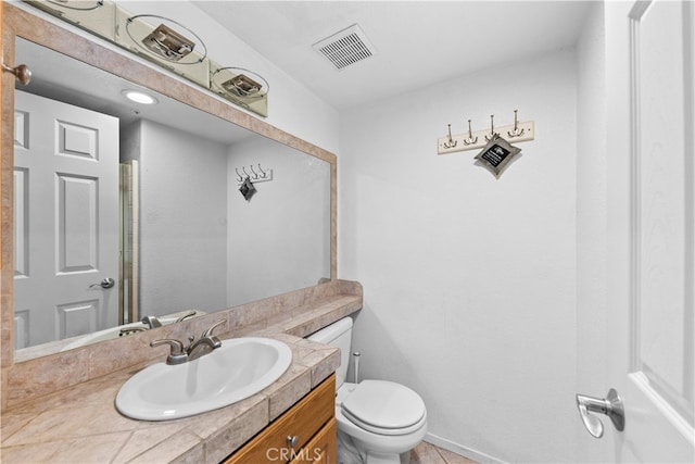 bathroom featuring vanity, tile patterned flooring, and toilet