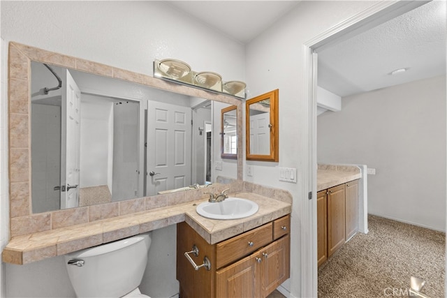 bathroom with vanity, toilet, and a textured ceiling