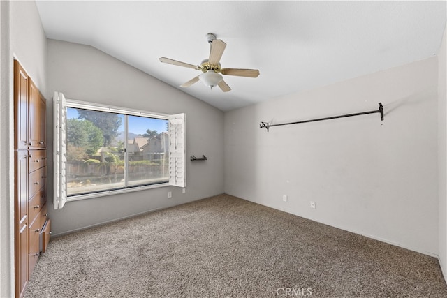 spare room with vaulted ceiling, carpet, and ceiling fan