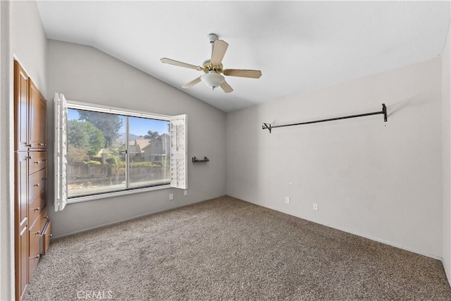empty room with lofted ceiling, carpet, and ceiling fan