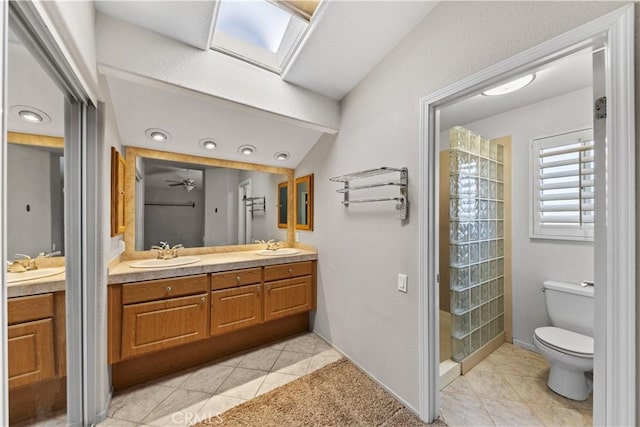 bathroom with toilet, tile patterned floors, a sink, and double vanity