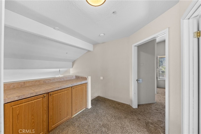 bar featuring lofted ceiling with beams, carpet floors, and a textured ceiling