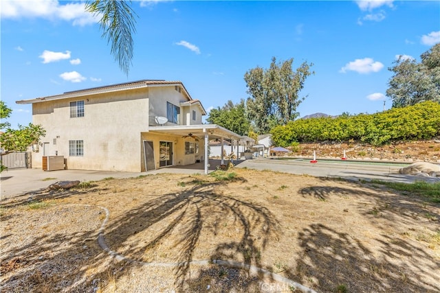 back of property with ceiling fan and a patio