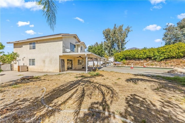 back of house featuring ceiling fan, a patio area, and stucco siding