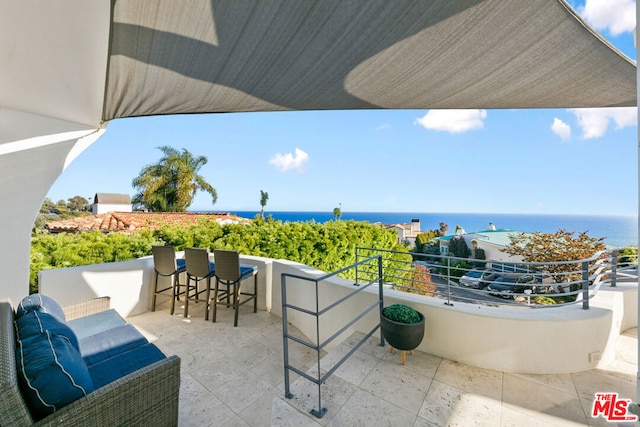 view of patio with a water view and a balcony