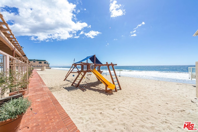 view of play area featuring a water view and a view of the beach