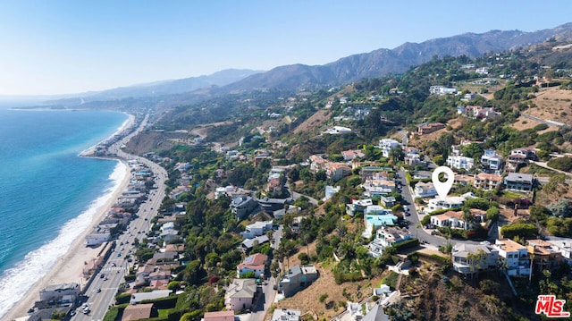 drone / aerial view with a view of the beach and a water and mountain view