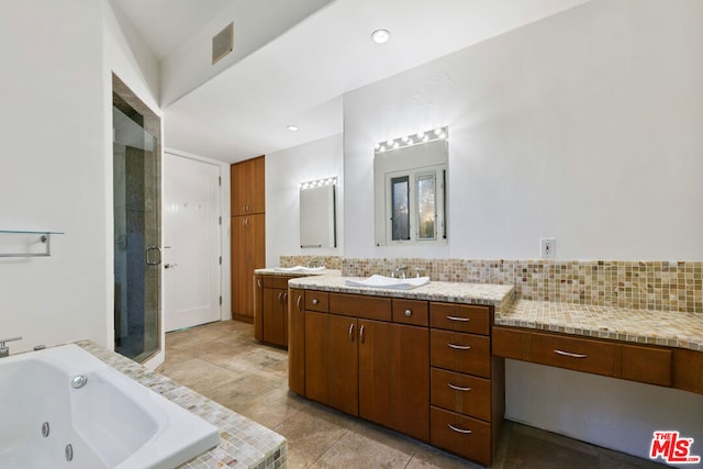 bathroom with plus walk in shower, decorative backsplash, vanity, and tile patterned floors