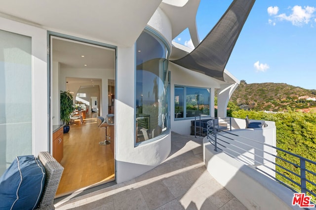 view of patio with a mountain view and a balcony