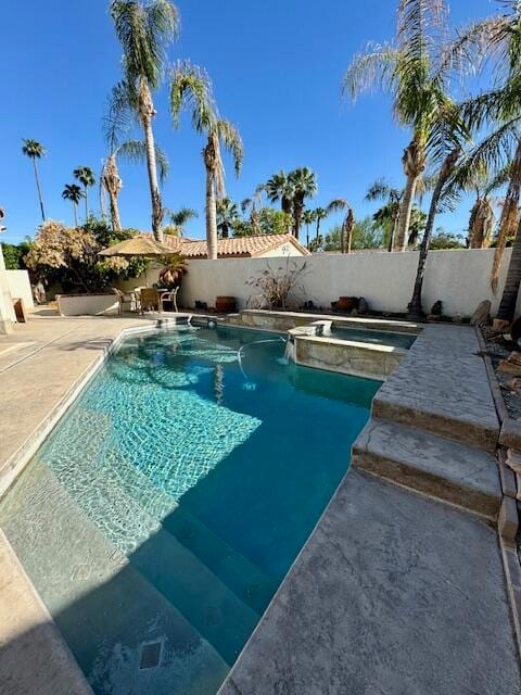 view of pool with an in ground hot tub