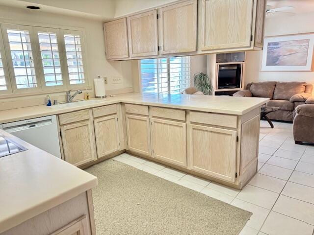 kitchen featuring ceiling fan, kitchen peninsula, light brown cabinetry, and a healthy amount of sunlight