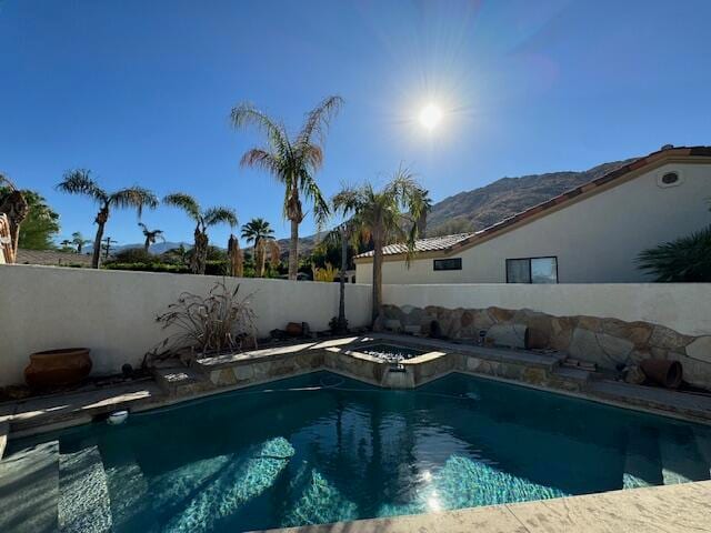 view of swimming pool featuring a mountain view and an in ground hot tub