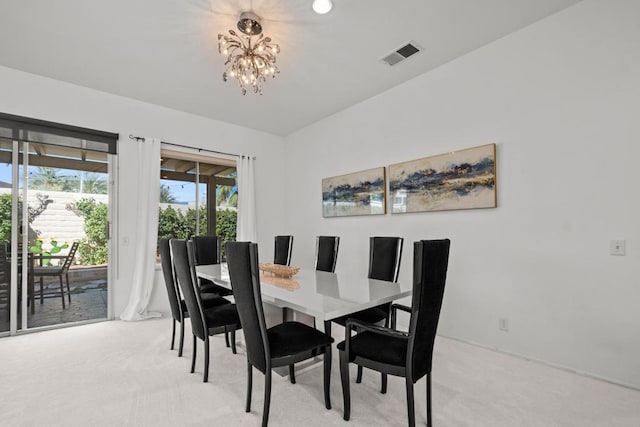 carpeted dining space featuring a notable chandelier