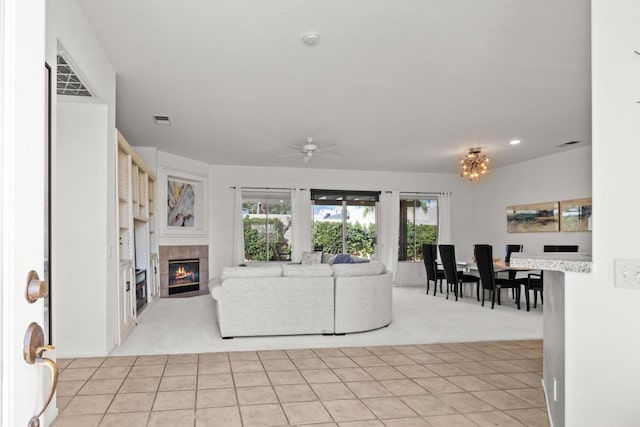 living room featuring ceiling fan, a fireplace, and light colored carpet