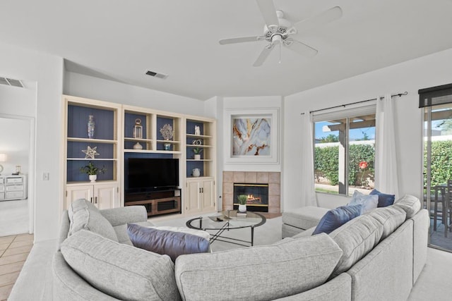 living room with ceiling fan, light tile patterned floors, and a fireplace