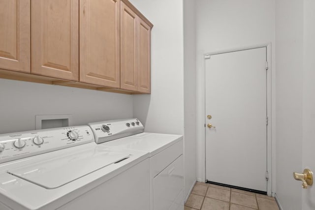 laundry room with separate washer and dryer, light tile patterned floors, and cabinets